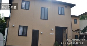 介護施設の建物外観。ベージュと茶色の2色配色の2階建て。
