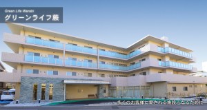 グリーンライフ恩那の建物外観。青と黄色のモダンな3階建て施設。
